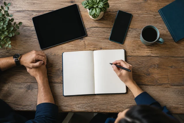 Carnet, téléphone et tablette sur une table de travail — visuel généré par IA